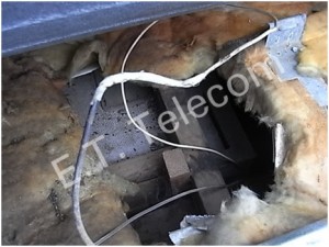 Multiple home wiring cable joins beneath a flat tin roof