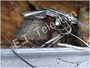 Multiple home wiring cable joins beneath a flat tin roof